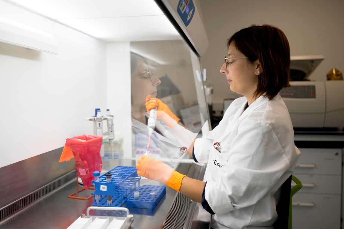 Scientist pipetting samples with reagents at the bench.