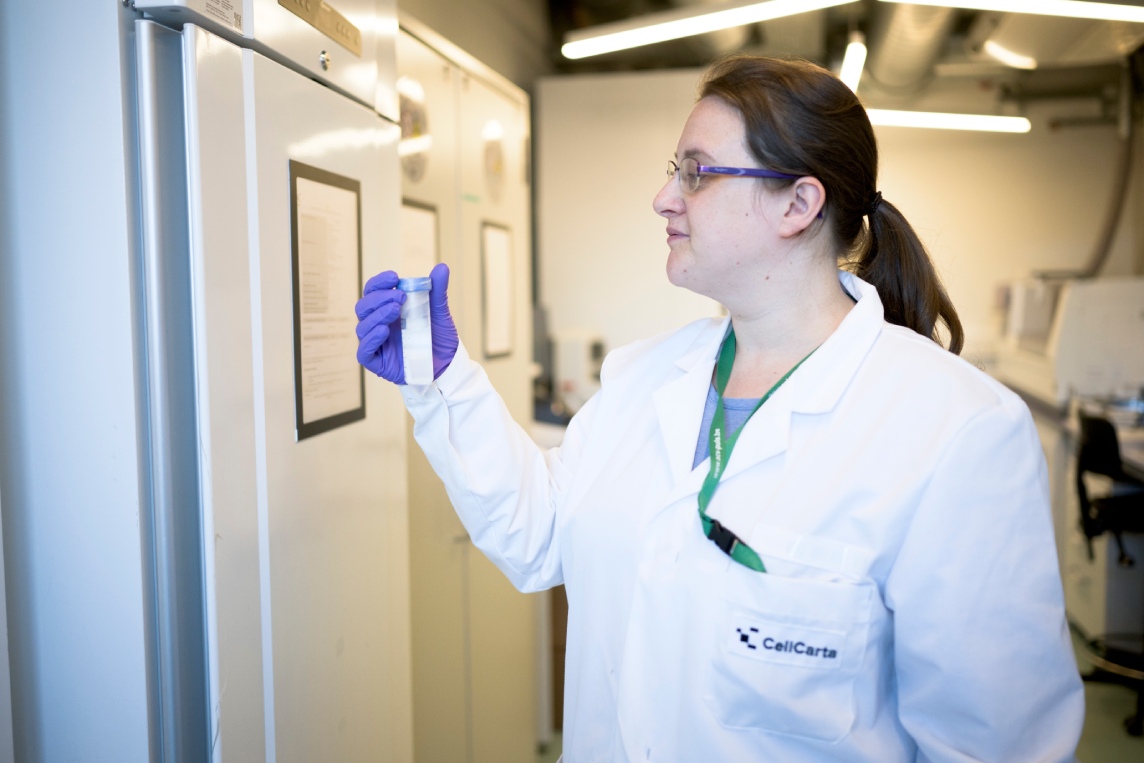 Scientist inspecting a sample vial in the laboratory.