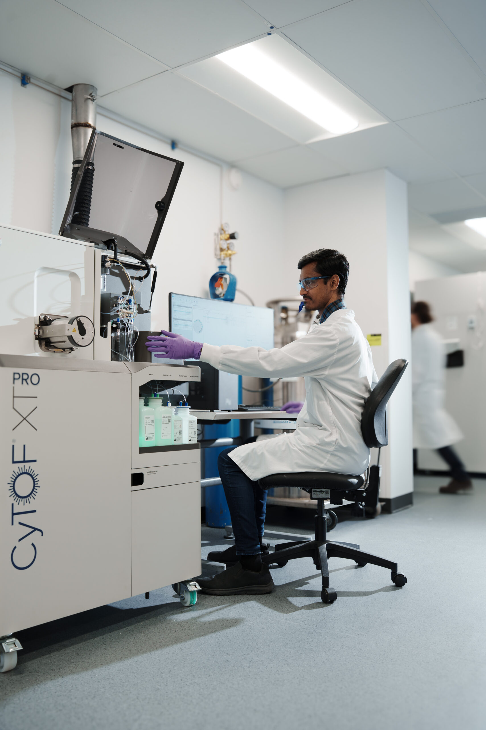 Scientist operating CyTOF mass cytometry instrument in laboratory